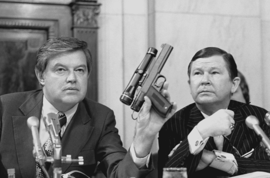 Frank Church holds CIA poison dart gun at committee hearing with vice chairman John Tower on September 17, 1975 (Source: U.S. Capital, photo by Henry Griffin)